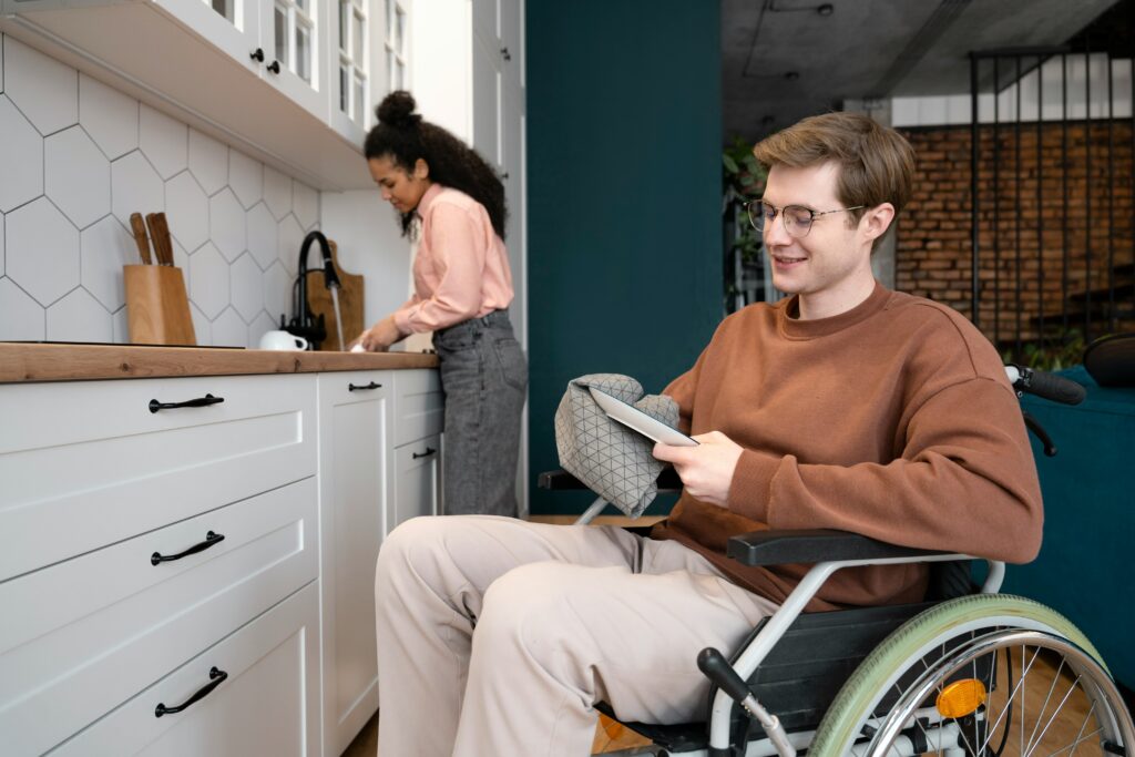 Man in wheelchair washing dishes in ADA compliant ADU.