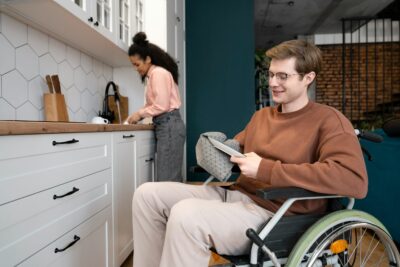 Man in wheelchair washing dishes in ADA compliant ADU.